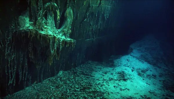 The wreckage of the Titanic showing its anchor and the surrounding ocean floor, illuminated by underwater light. the Titanic's anchor